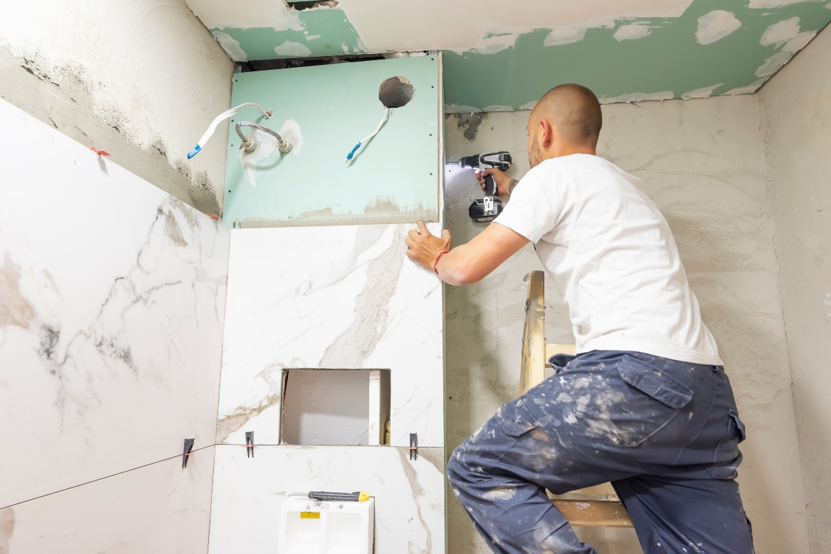 A man performing a bathroom remodel to add value to his home