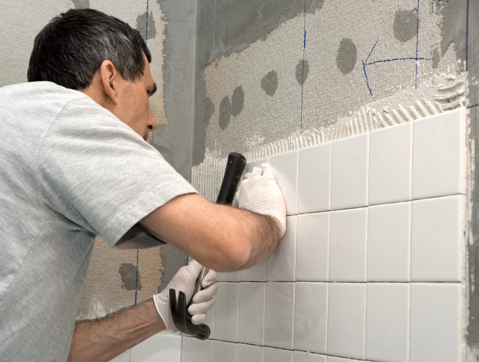 Bathroom remodel contractor working on bathroom tile