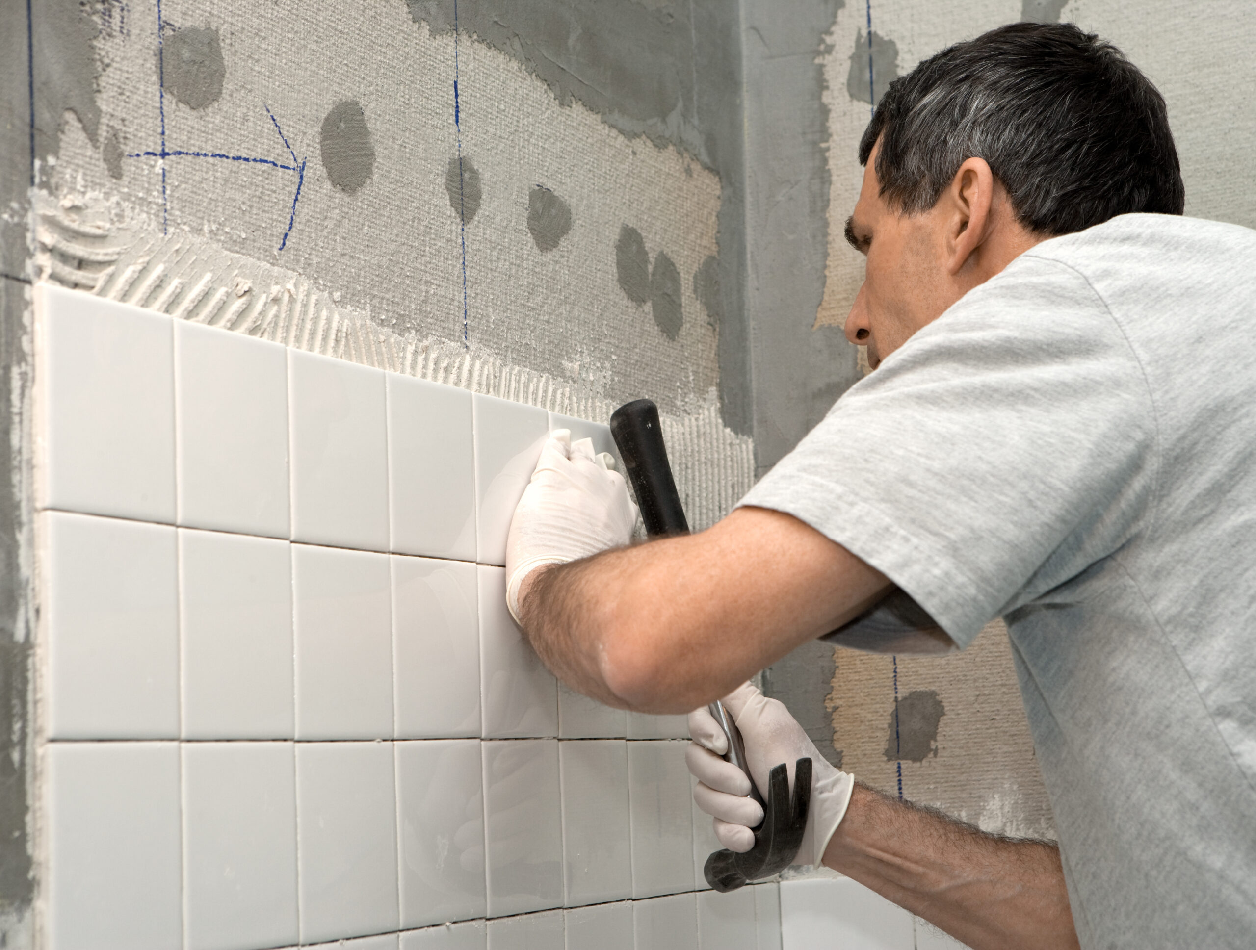 Bathroom remodel contractor working on bathroom tile