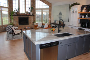 Open concept kitchen with the kitchen island near a naturally lit living area. 